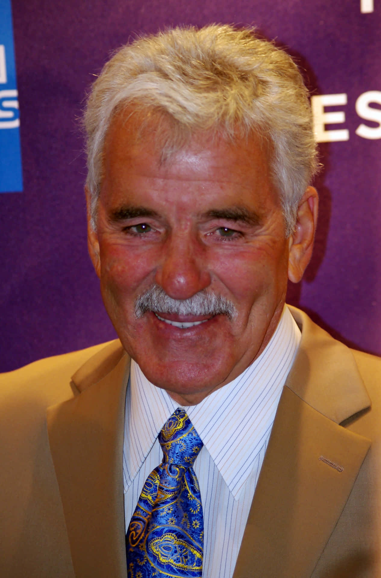 Dennis Farina posing for a photo with his iconic smile Wallpaper