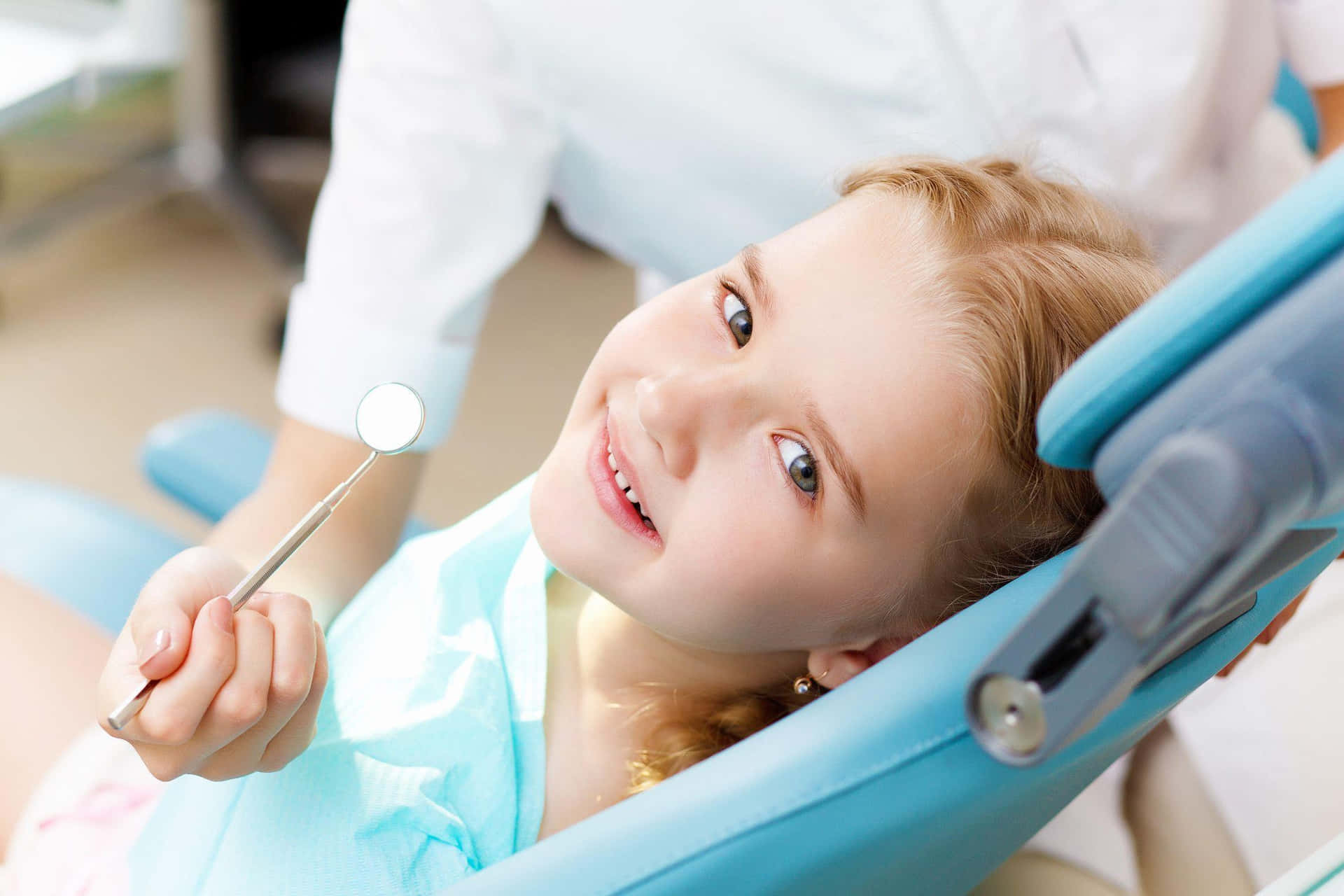 A Young Girl Is Sitting In A Dentist Chair