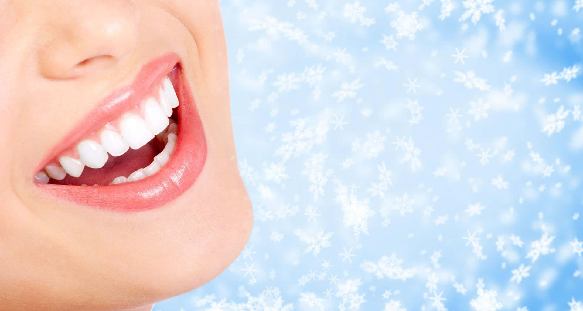 A Woman Smiling With Snowflakes On Her Teeth