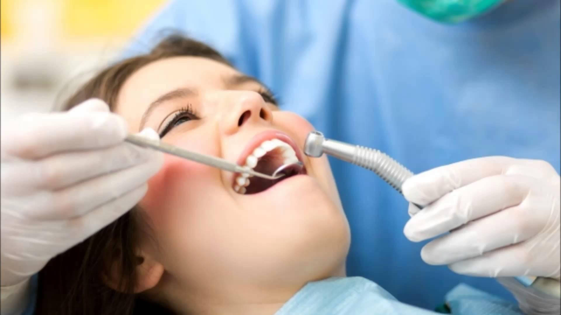 En tandlæges patient smiler under en procedure. Wallpaper