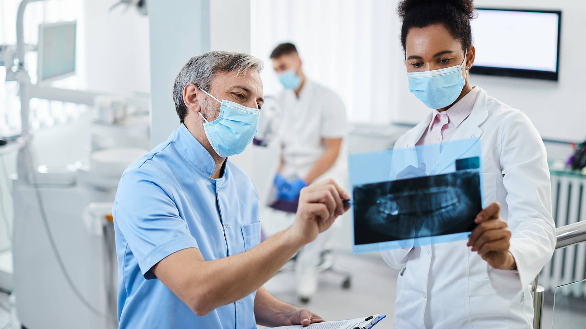 Dentistastrabajando Juntos Sobre Una Radiografía Por Rayos X Fondo de pantalla