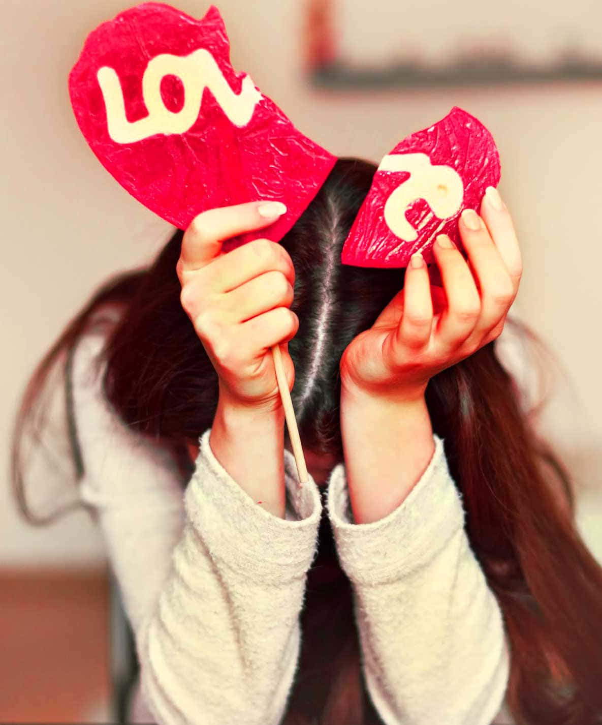 A Girl Holding Up A Heart With The Word Love