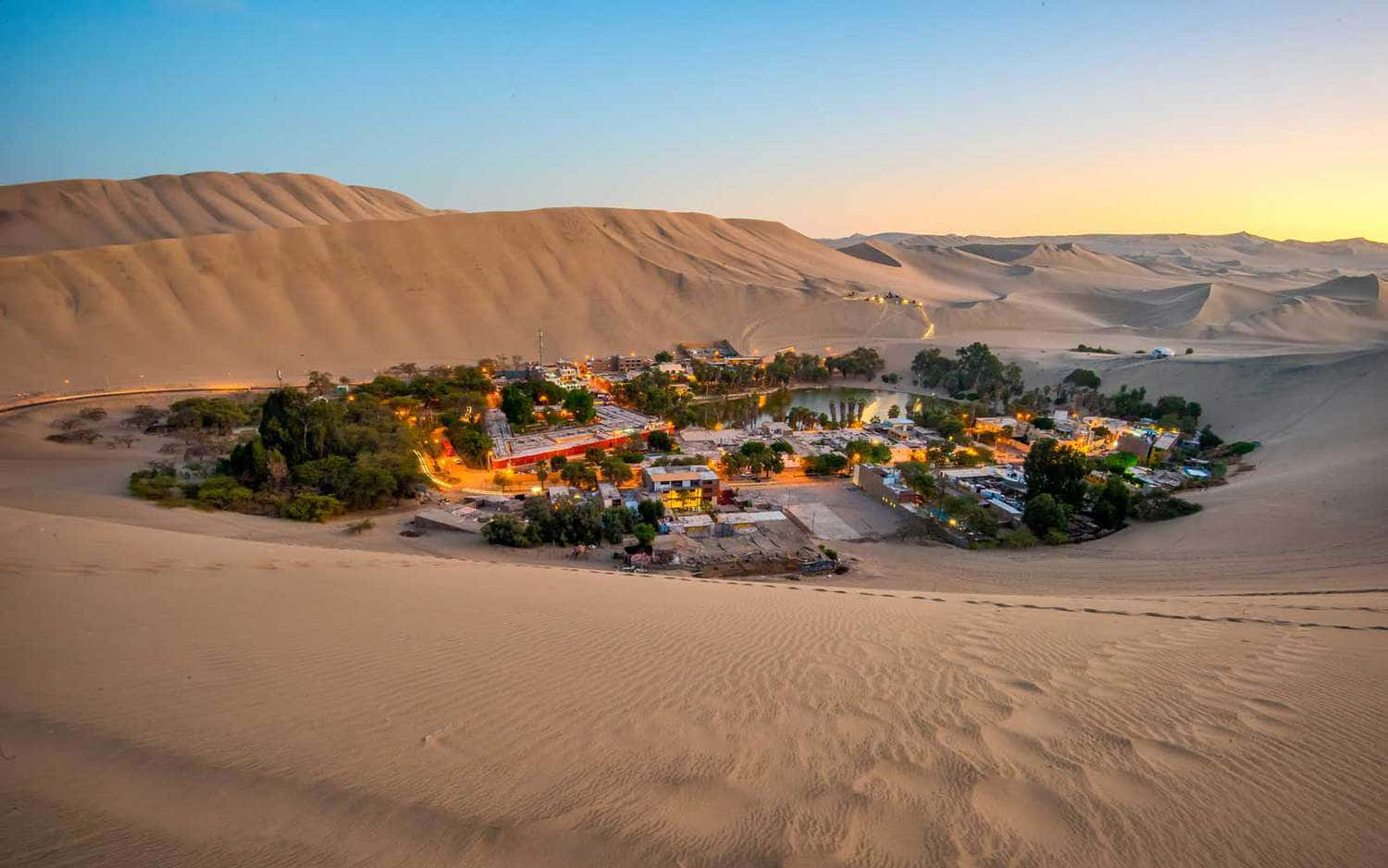 Unvillaggio È Circondato Dalle Dune Di Sabbia Al Tramonto.