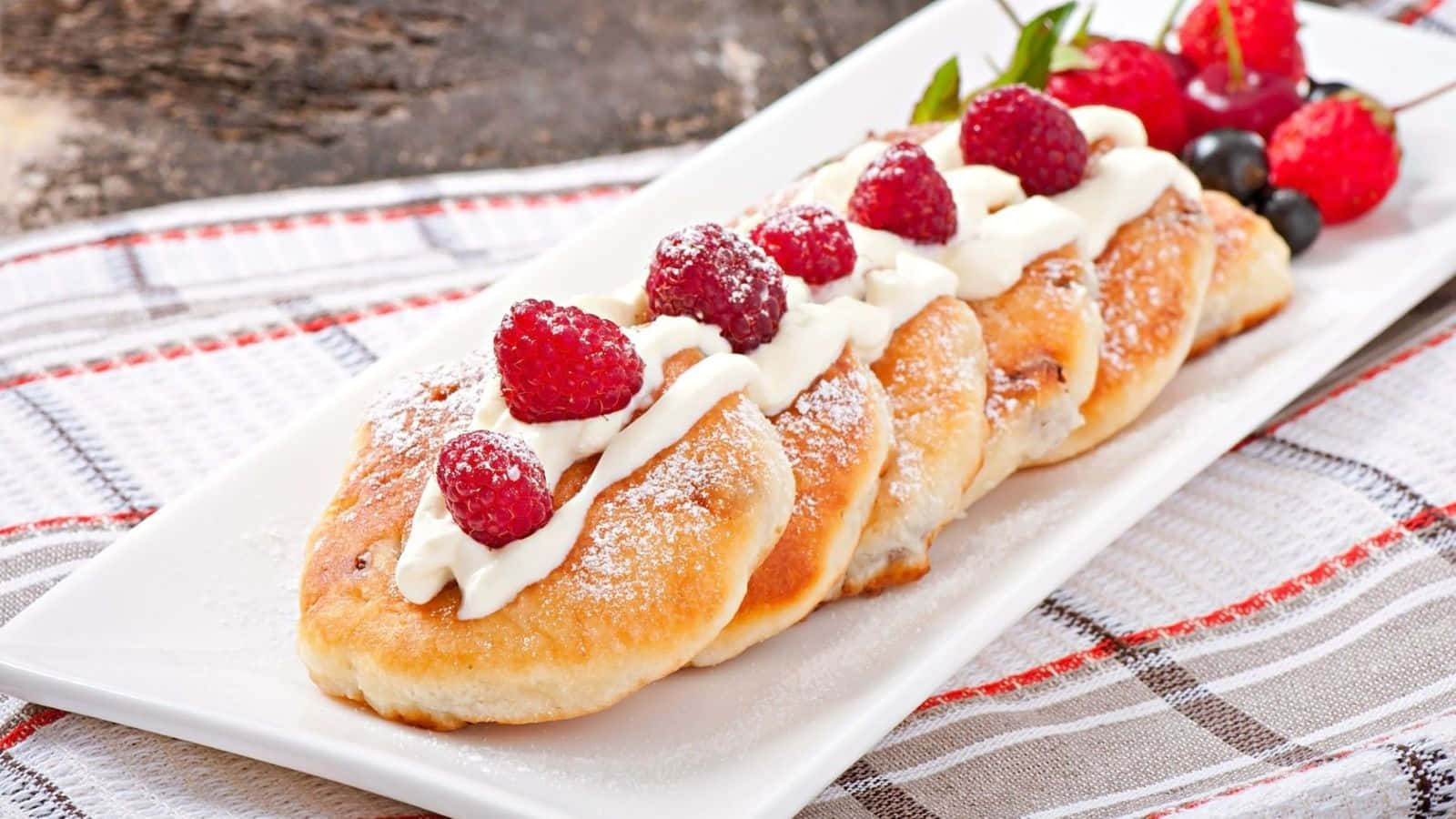 A Plate Of Pastries With Berries And Cream