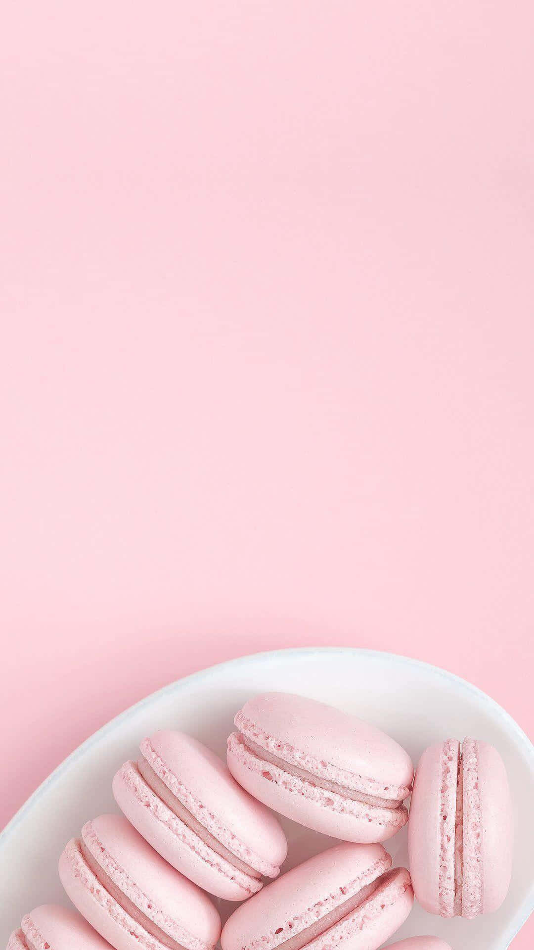 lyserøde macaroner på et fad på en lyserød baggrund Wallpaper