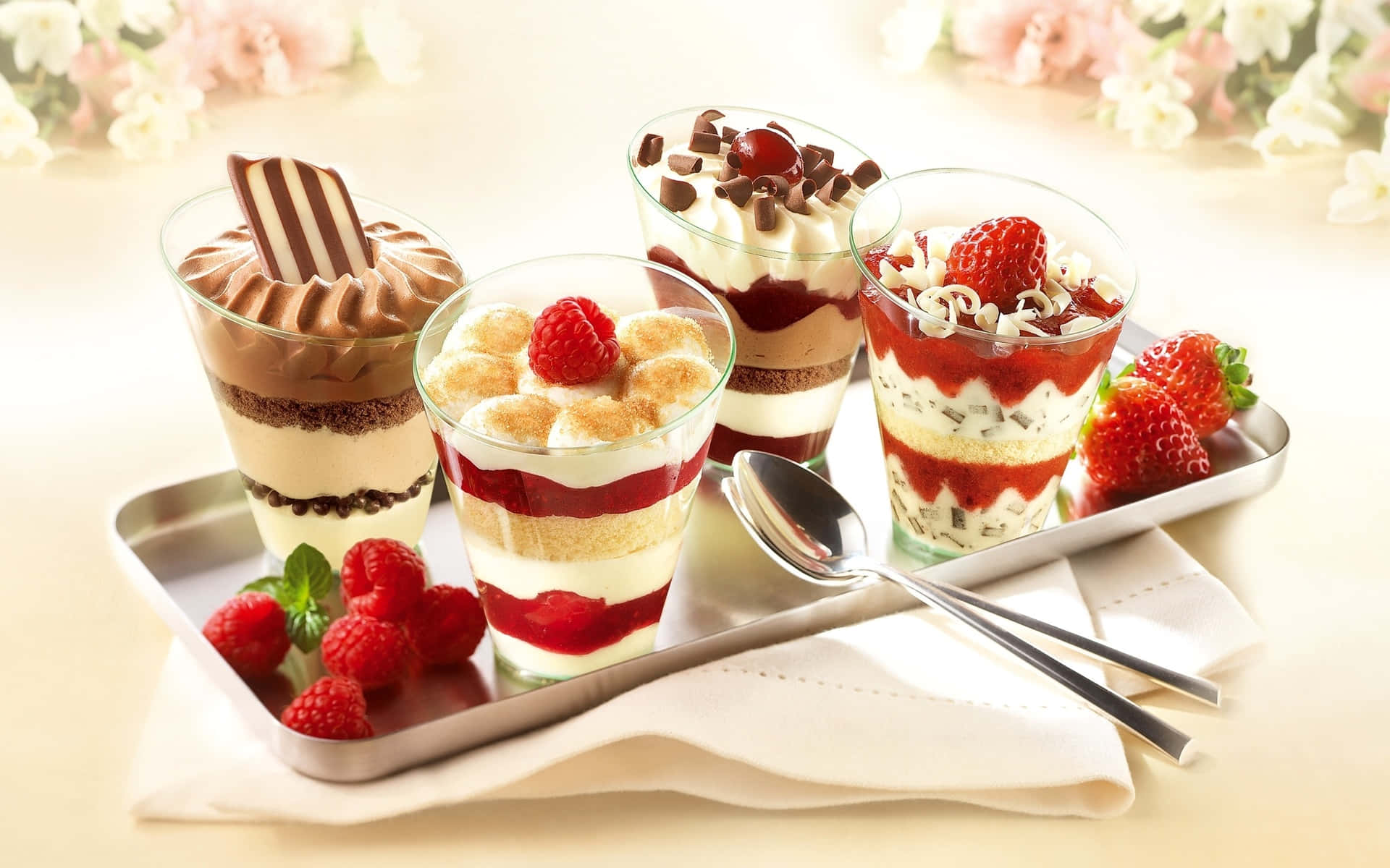 A Tray Of Desserts With Strawberries And Cream