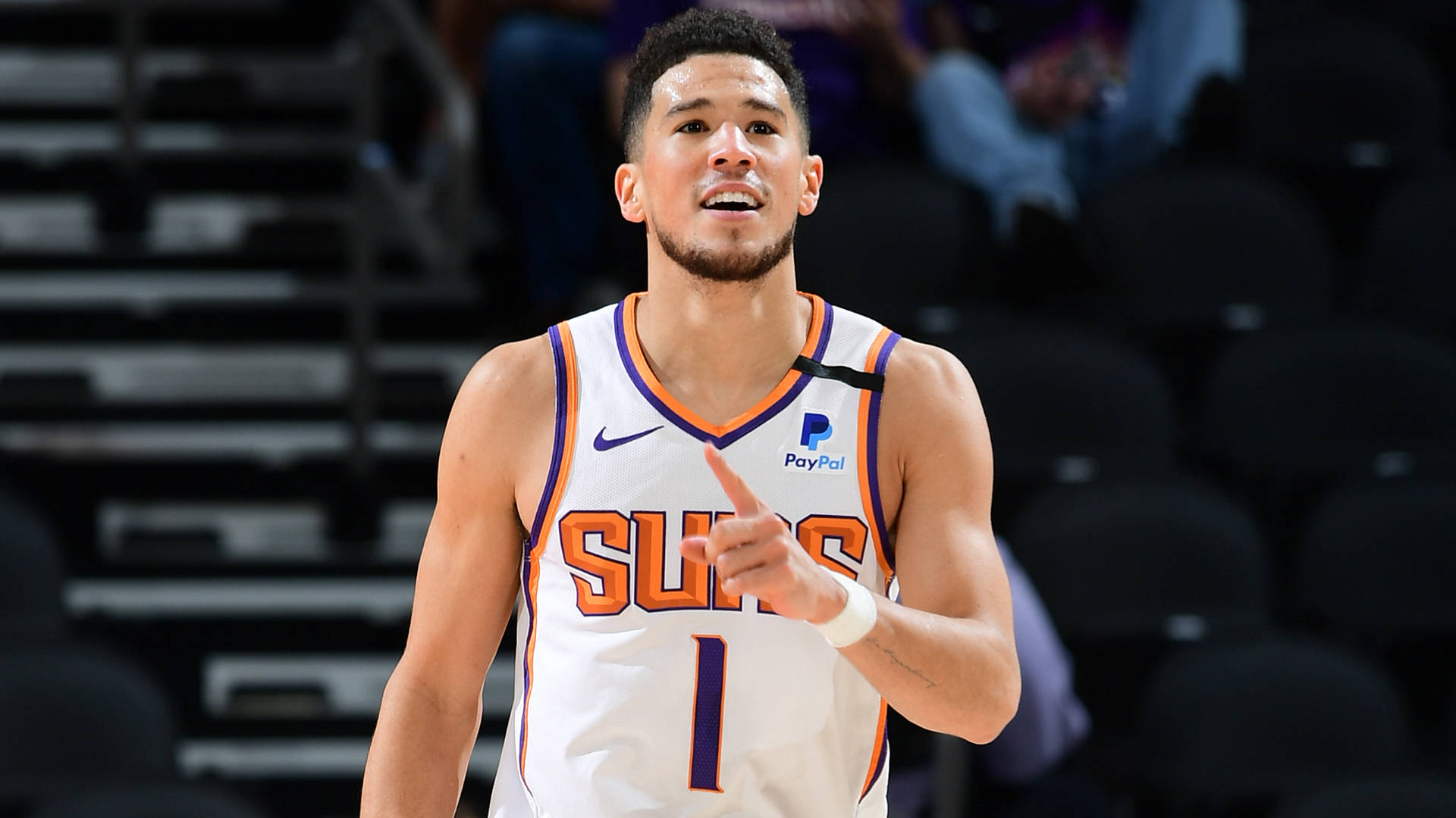 Devin Booker Smiling With Hand Raised Wallpaper