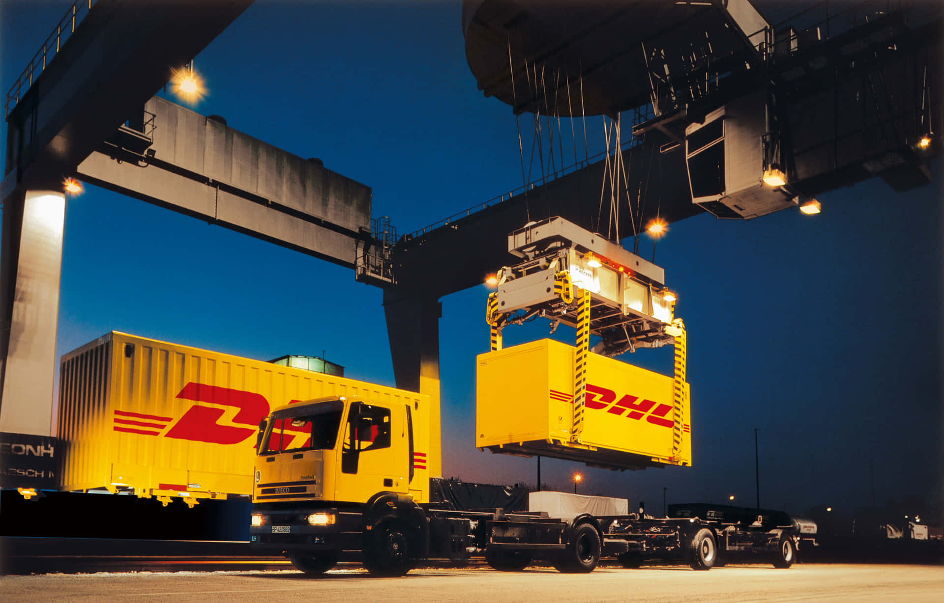 A Yellow Truck Is Lifting A Container