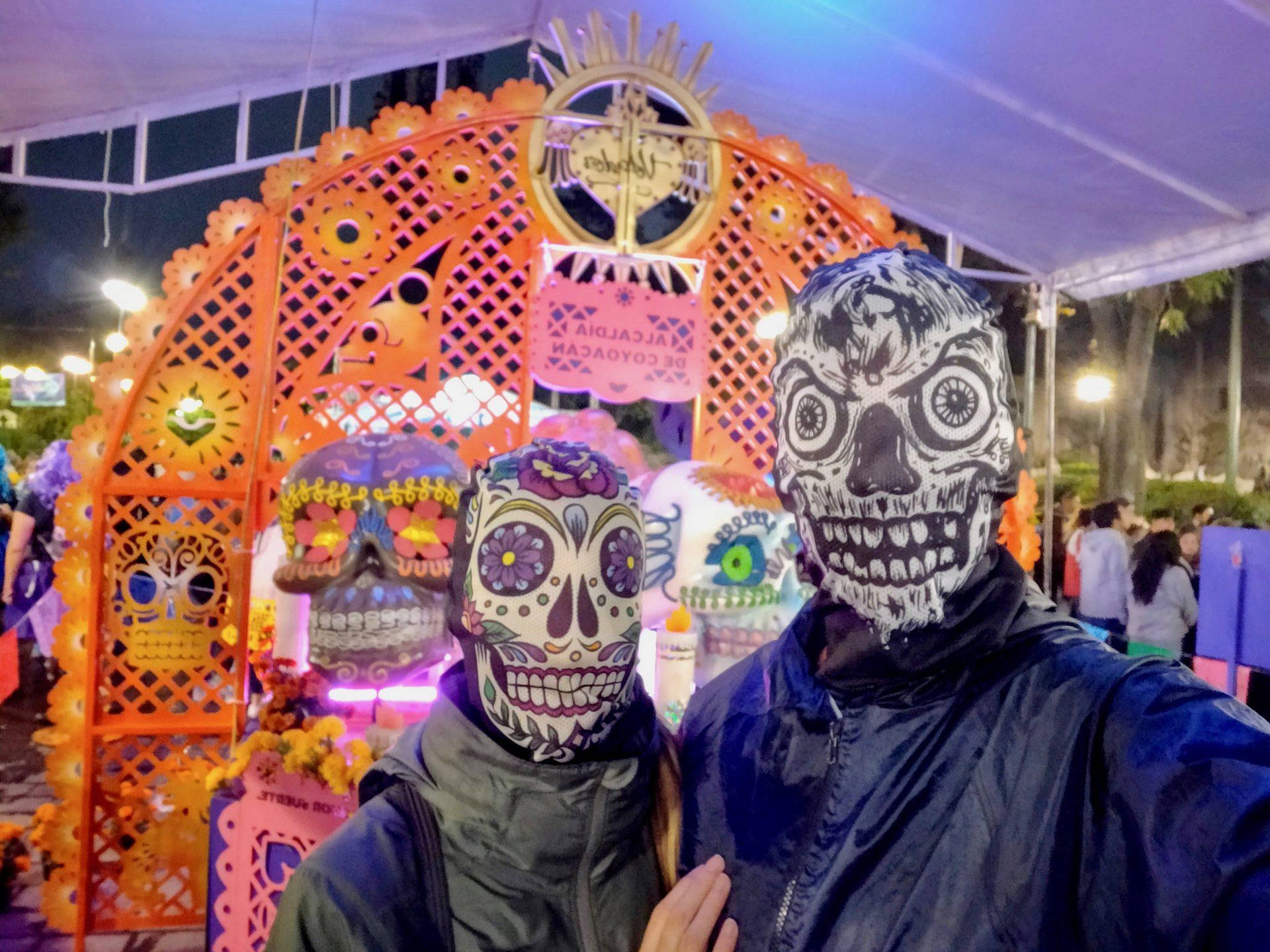 Celebrating Dia De Los Muertos - Two People in Vibrant Skull Masks Wallpaper