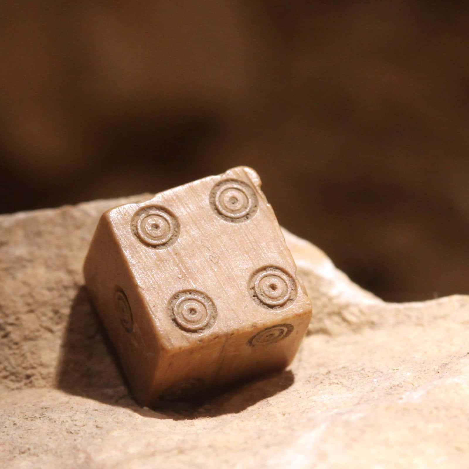 A Wooden Dice Sitting On A Rock