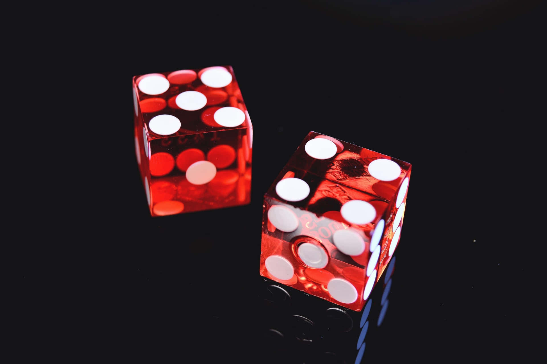 Two Red Dice On A Black Surface