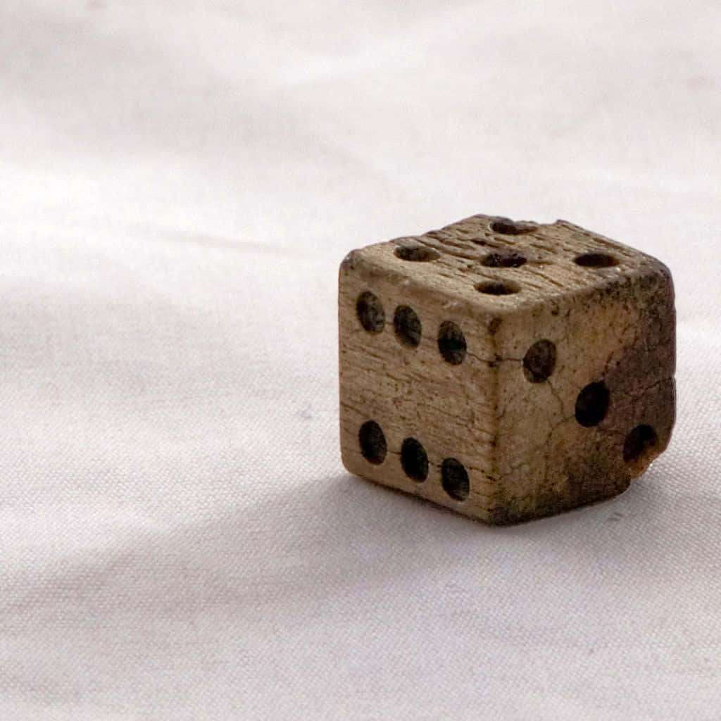 A Small Wooden Dice On A White Surface