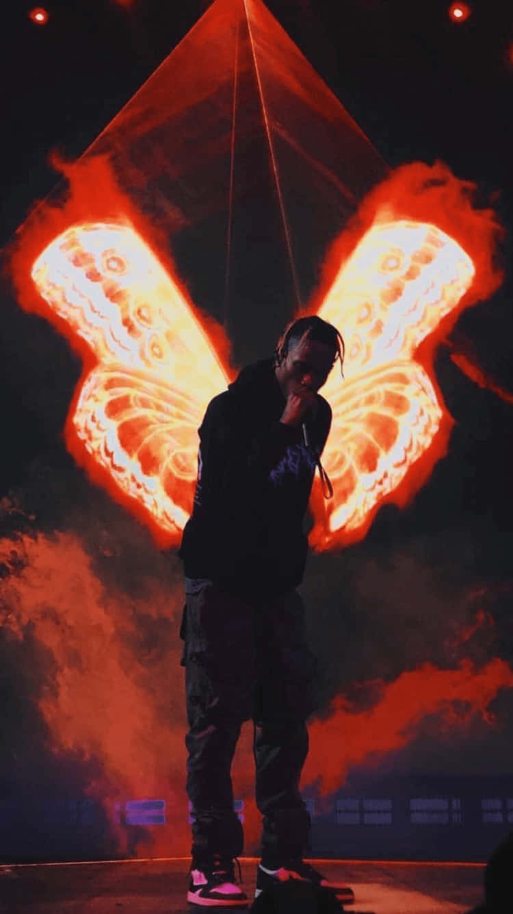 A Man Standing On Stage With Wings On His Shoulders Wallpaper