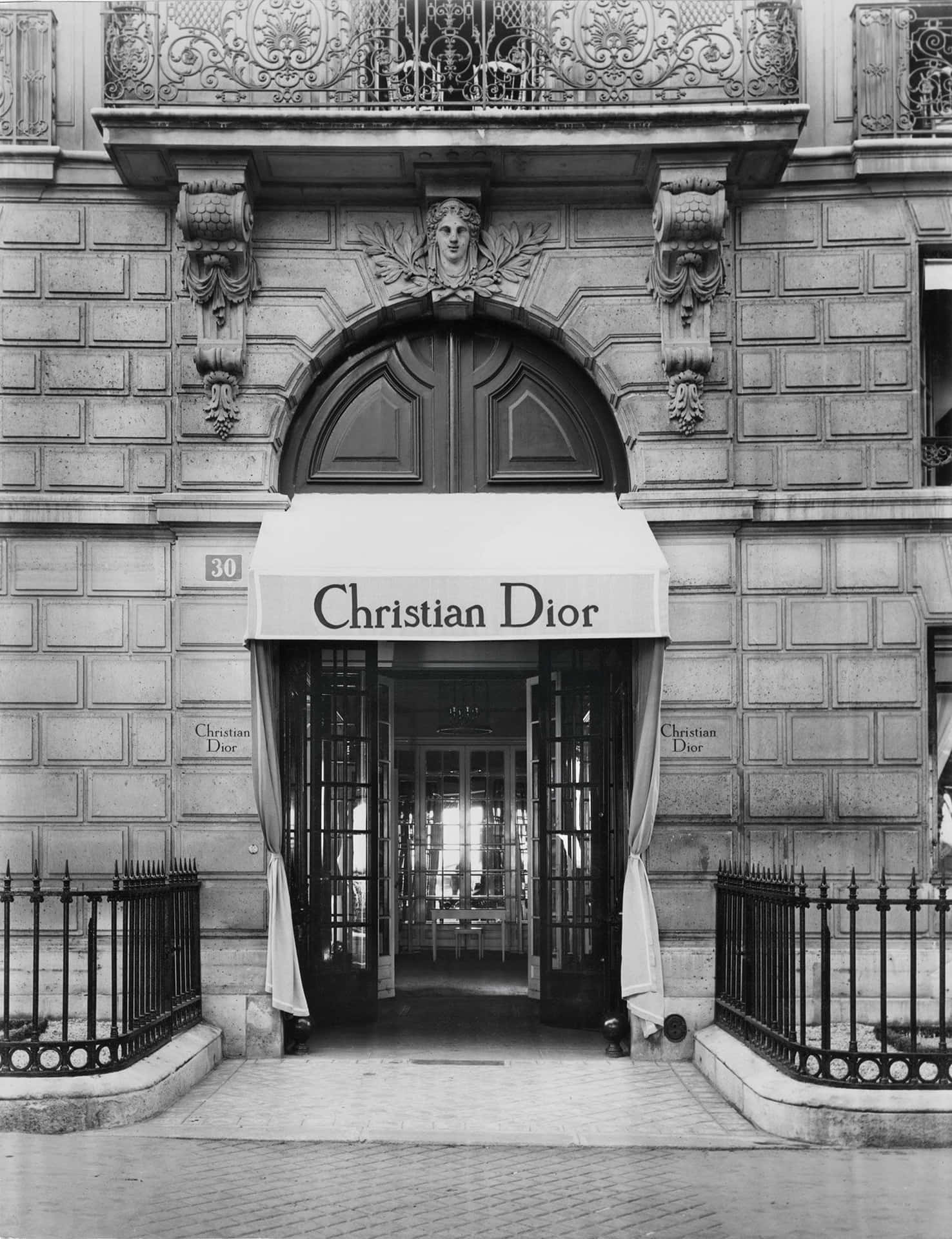 A Black And White Photo Of A Building With A Sign For Christian Dior