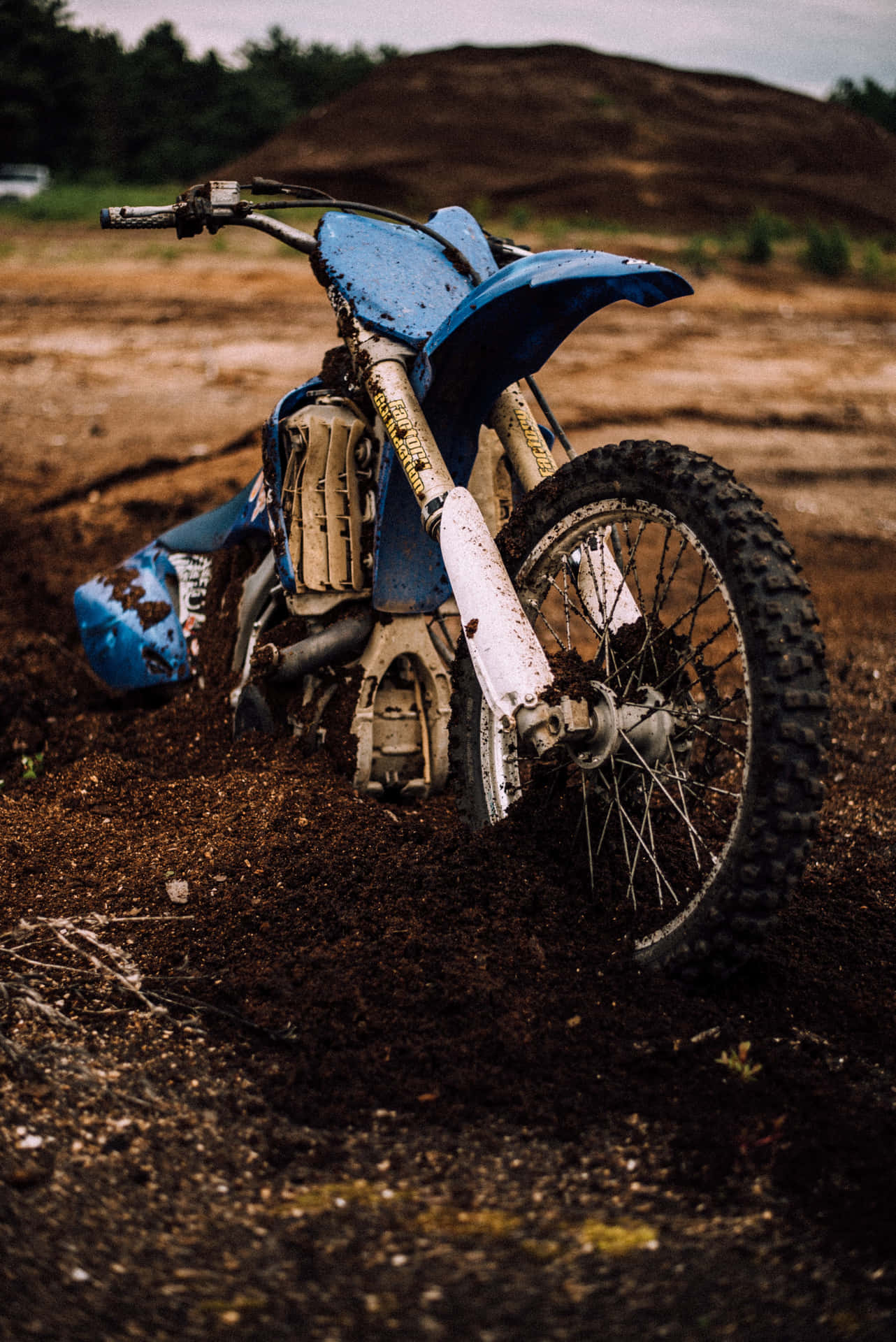 A Blue Dirt Bike Laying In The Dirt