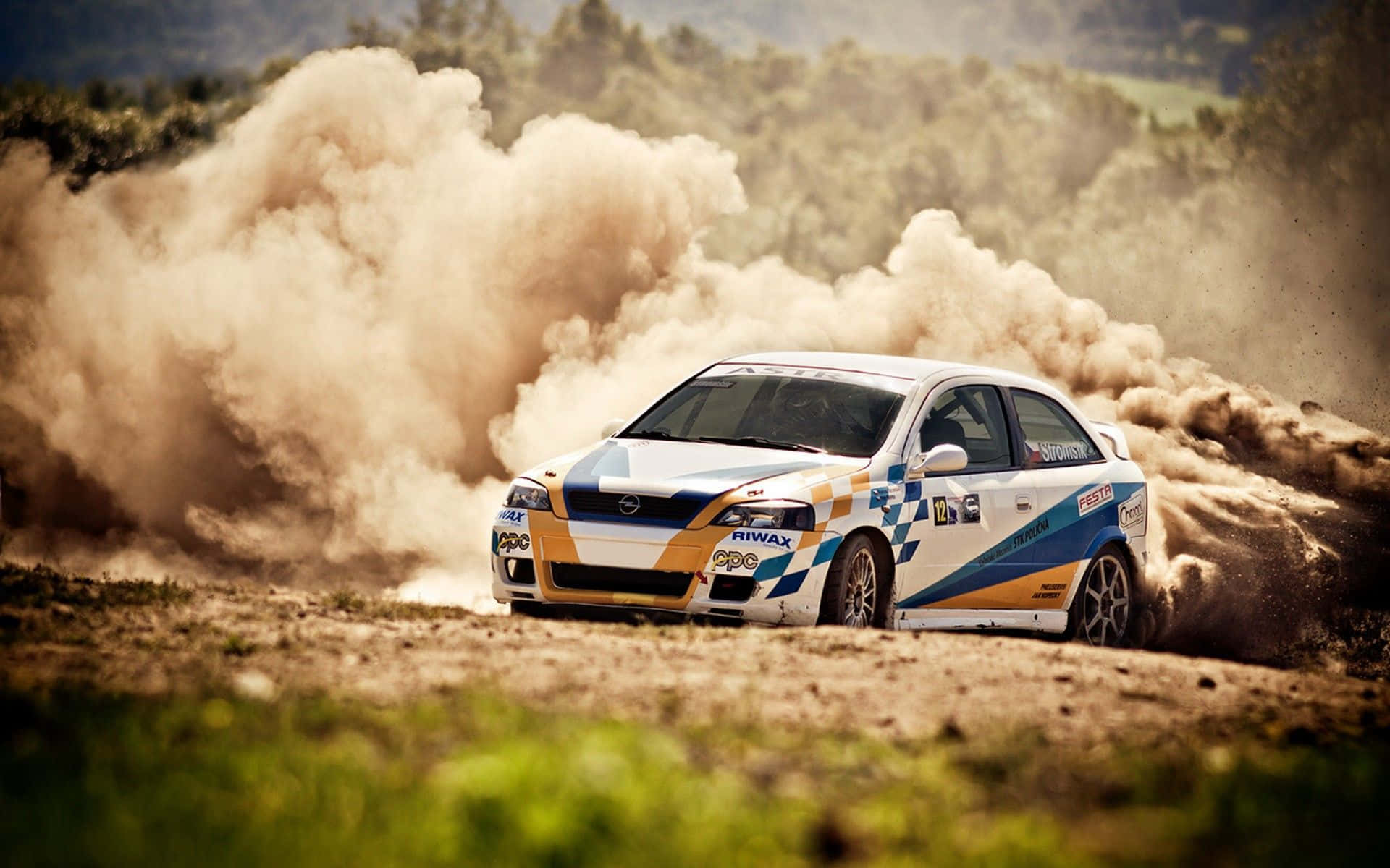 A Rally Car Driving Through A Dusty Field