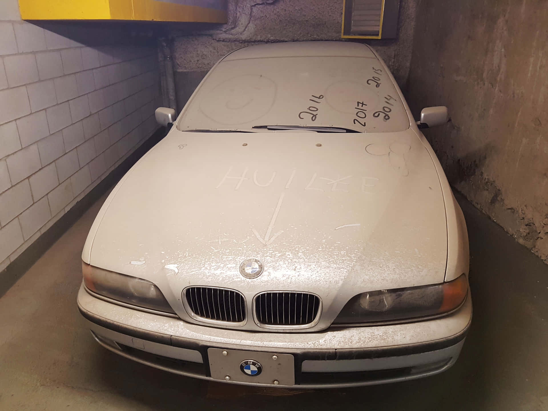 a white car is parked in a parking garage