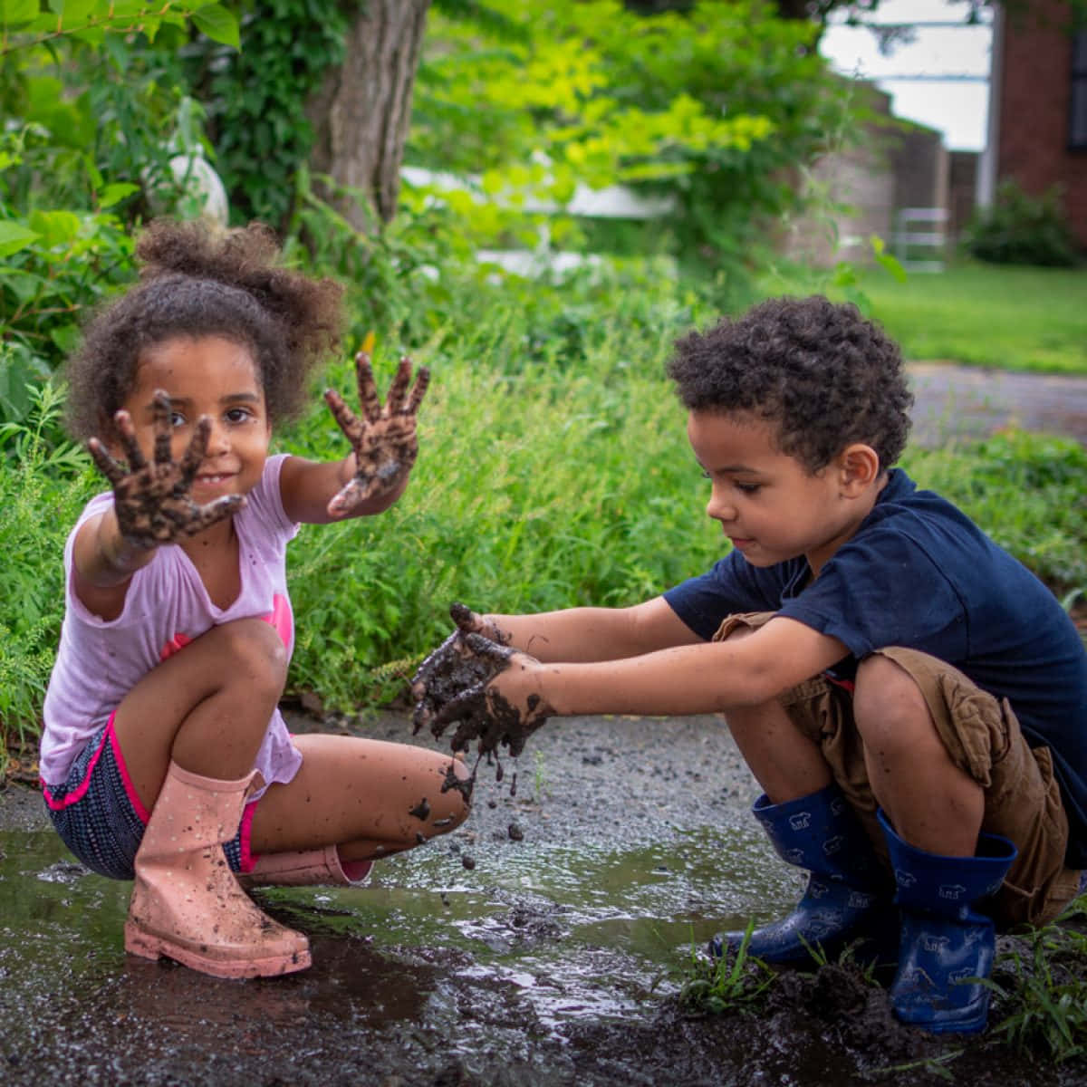 two children playing in the mud