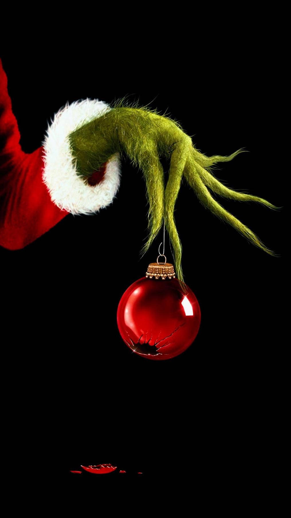 Caption: The Grinch Holding a Christmas Ball - Disney Christmas Theme for iPhone Wallpaper
