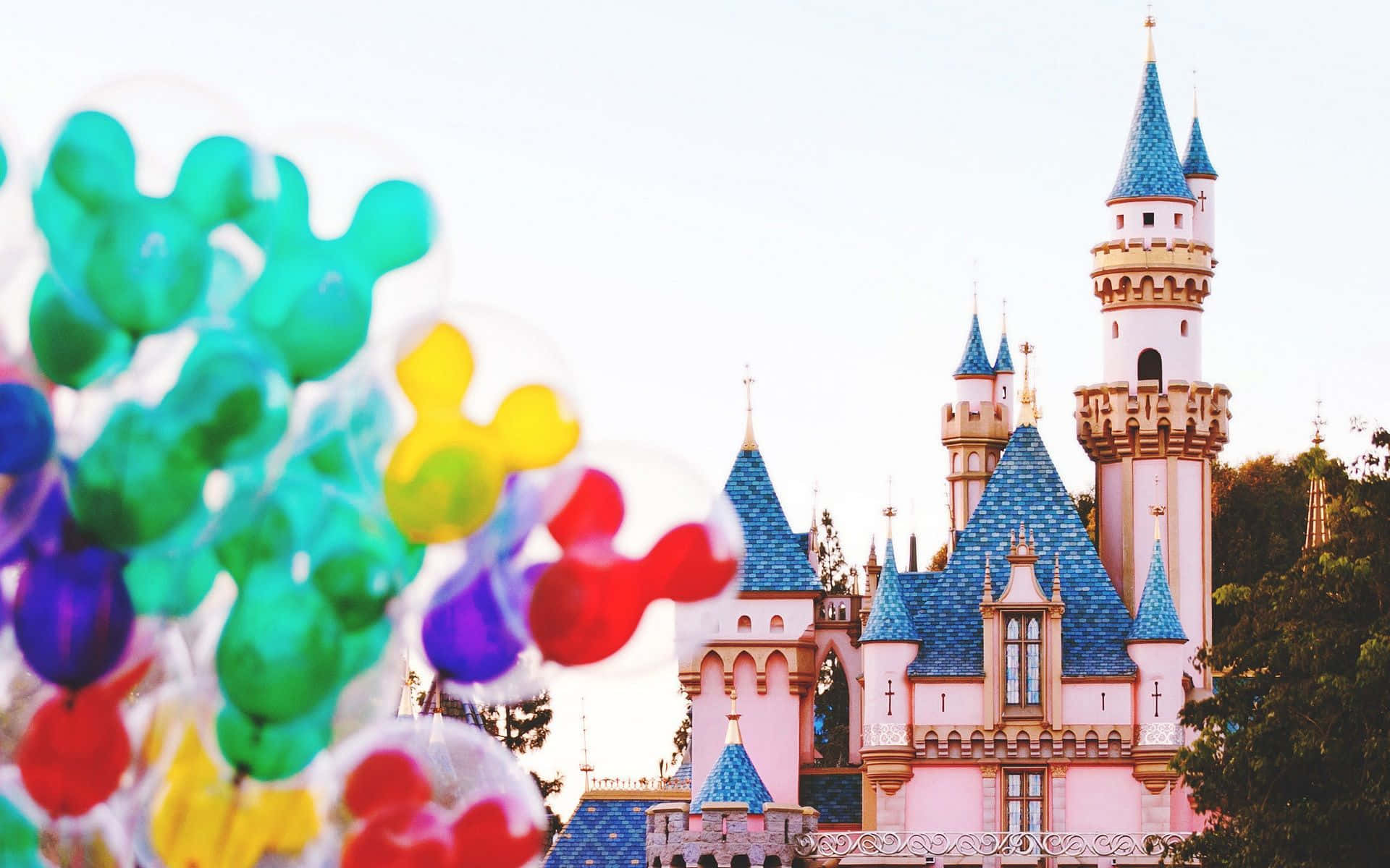 disney's cinderella castle with colorful balloons in front of it Wallpaper