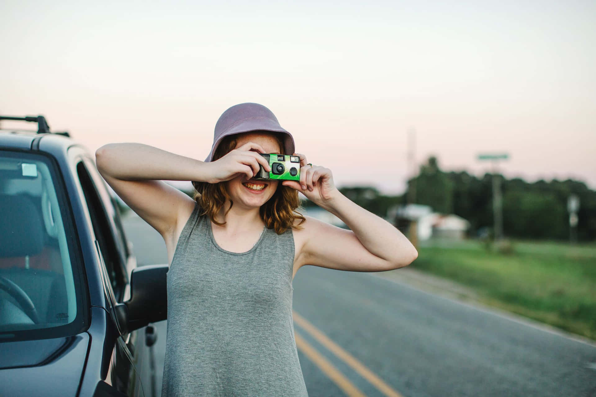A Woman Taking A Picture Of Her Car