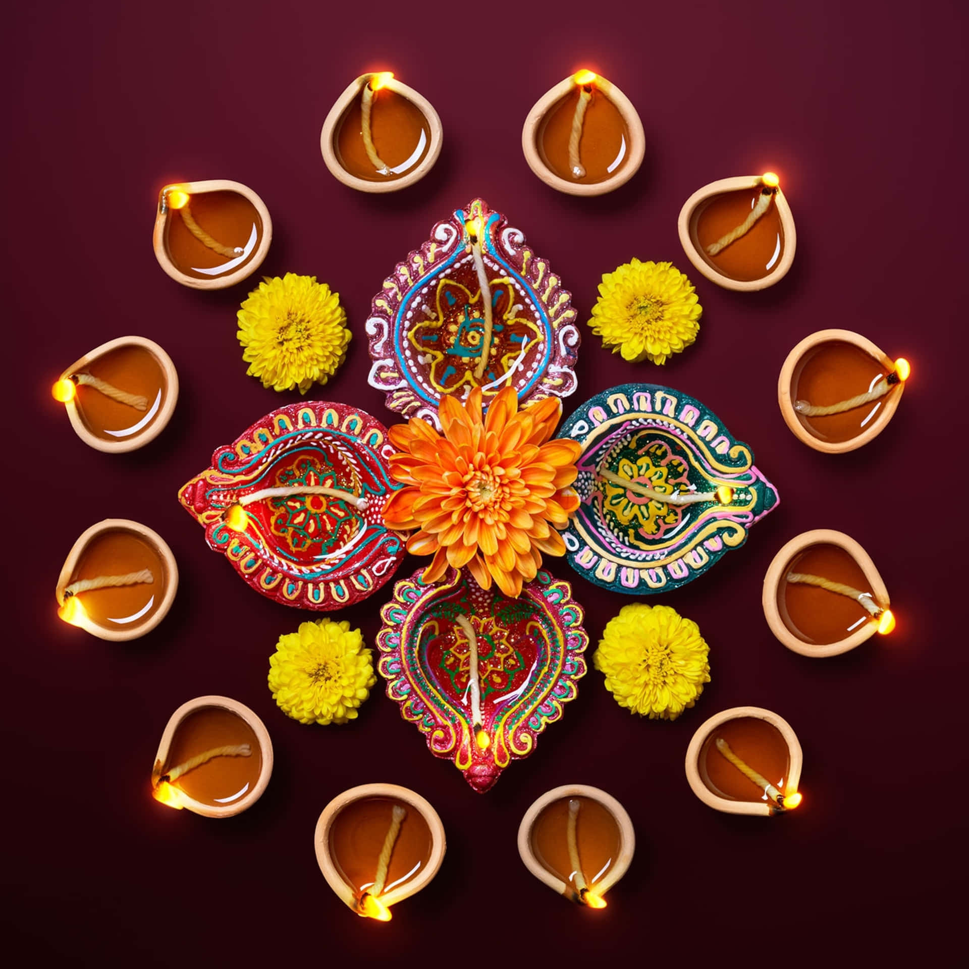 diwali diyas with colorful flowers and candles on a dark background