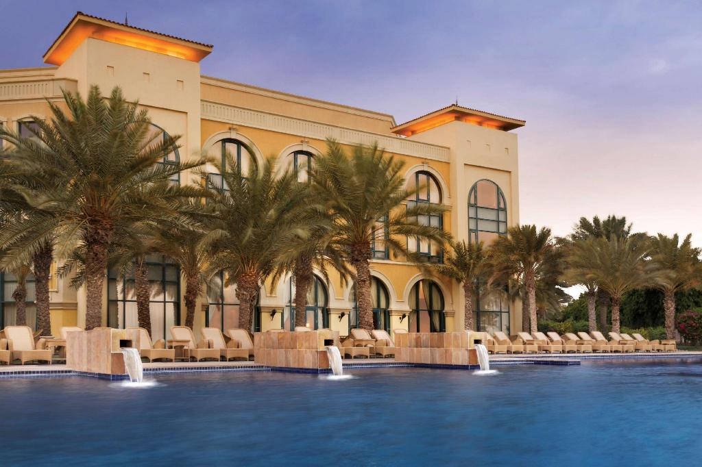 Caption: Scenic view of the luxurious Kempinski Palace in Djibouti surrounded by elegant palm trees. Wallpaper