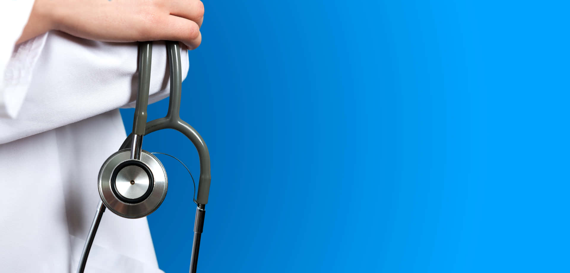 A Doctor Holding A Stethoscope Against A Blue Background