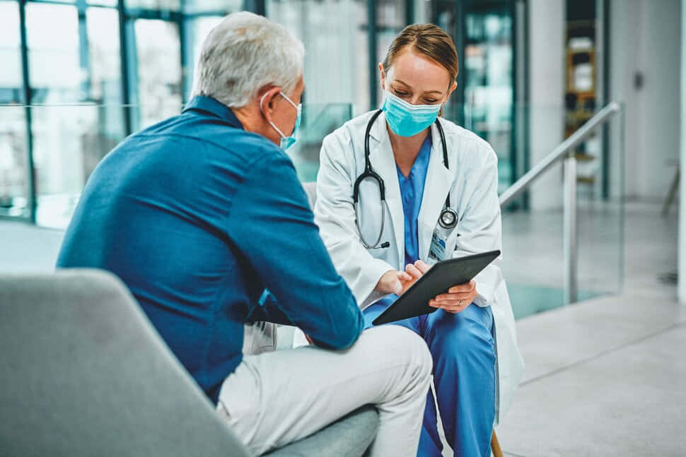 Unmédico Y Un Paciente Hablando En Una Tablet