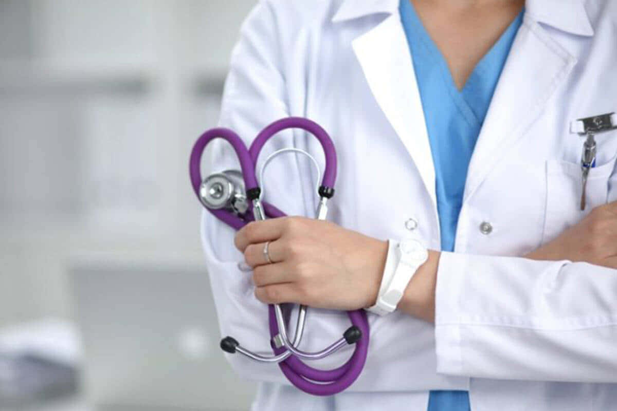 A Female Doctor Holding A Purple Stethoscope