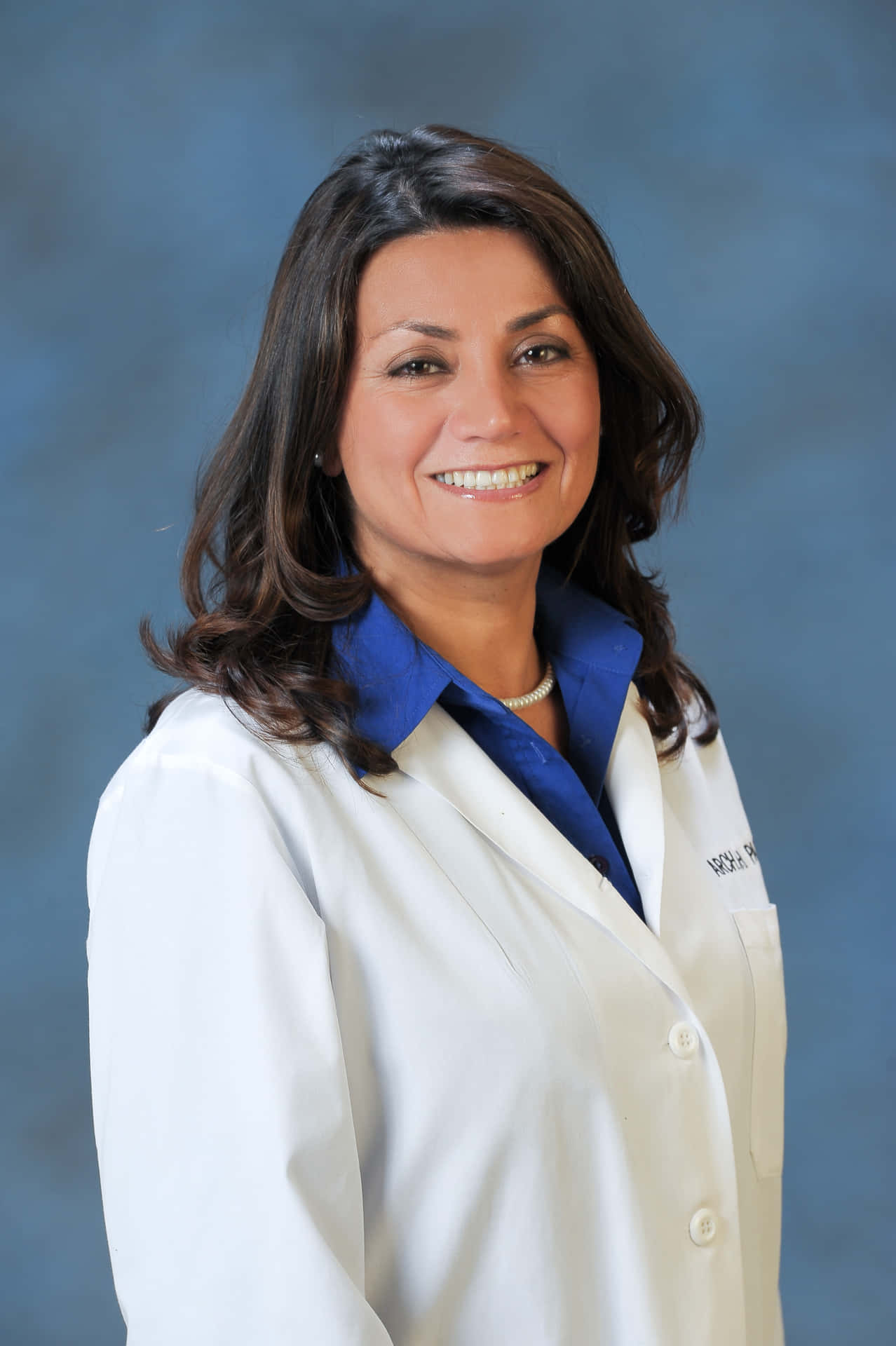 A Woman In A White Lab Coat Smiling