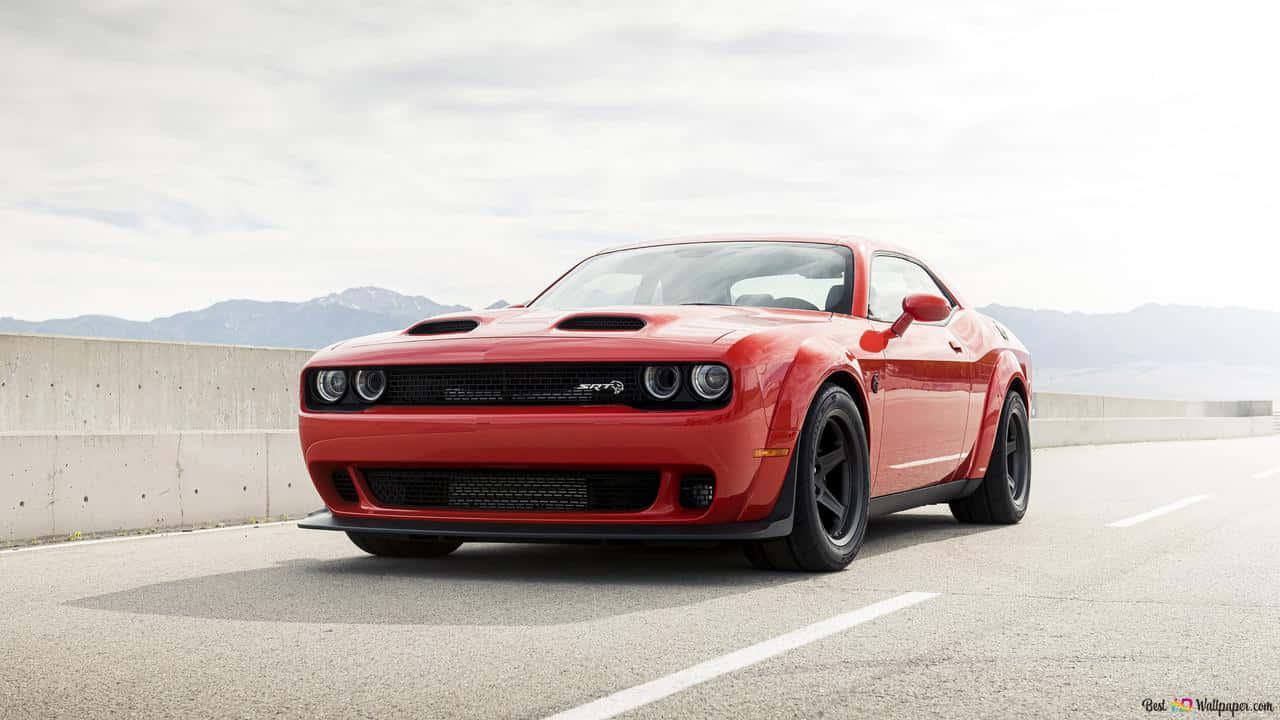 The Red Dodge Challenger Is Driving Down The Road Wallpaper
