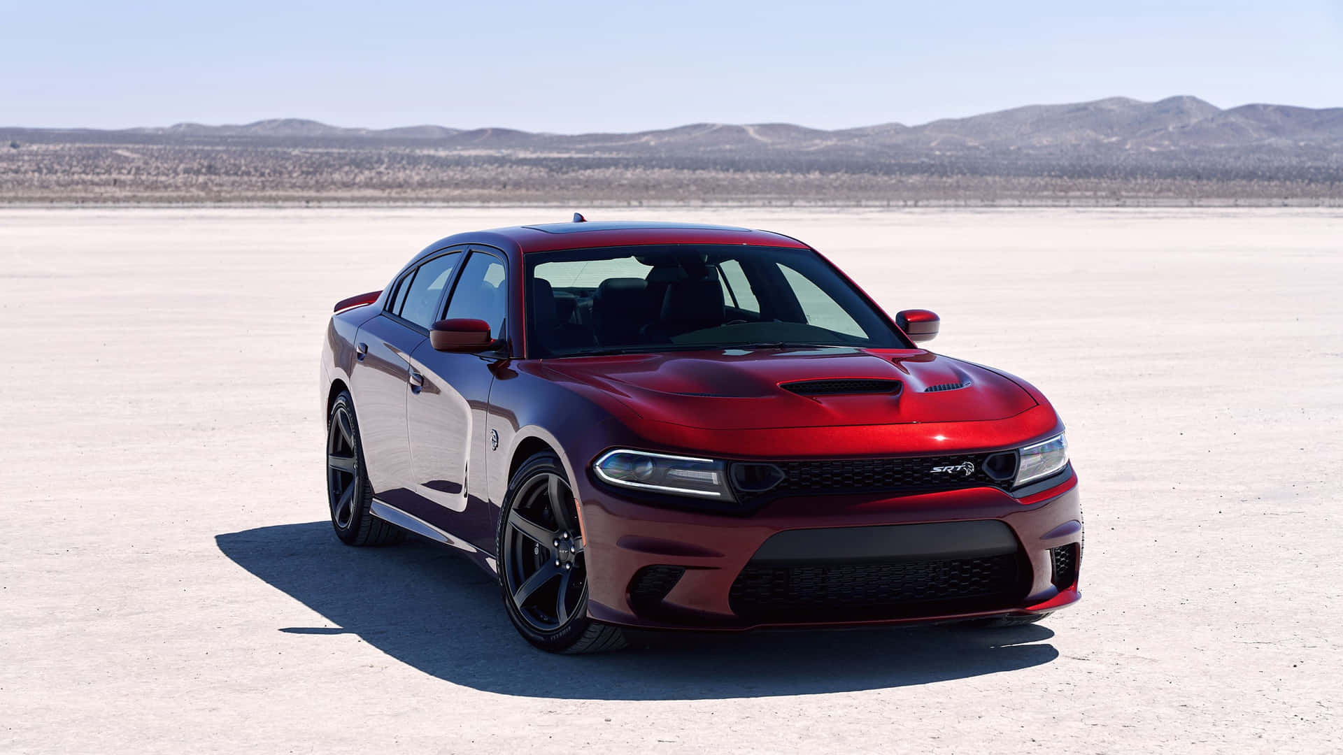 The Red Dodge Charger Srt Is Parked In The Desert Wallpaper