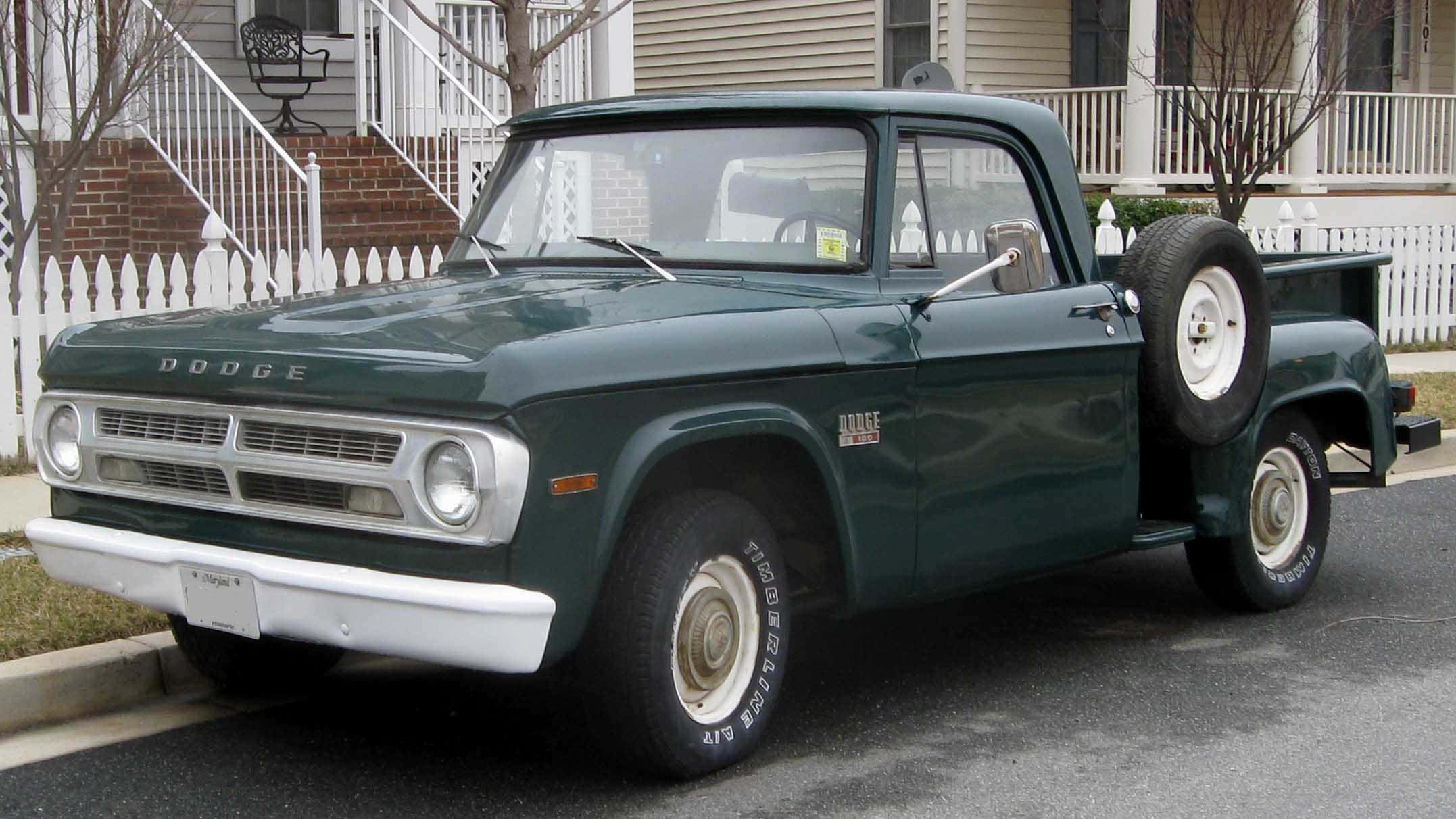 A Green Pickup Truck Parked On The Side Of The Street