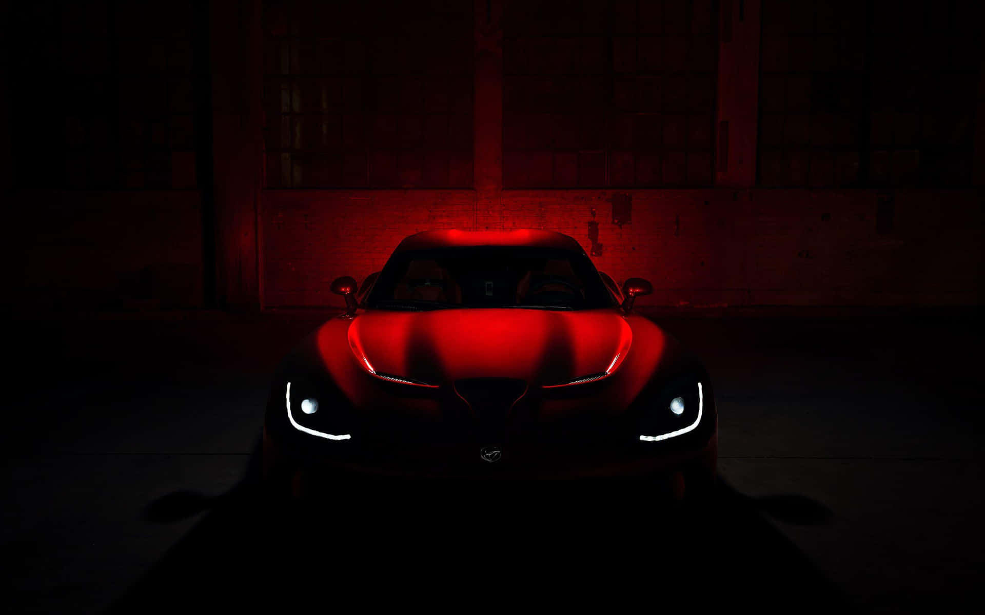 A Red Sports Car Is Lit Up In The Dark Wallpaper