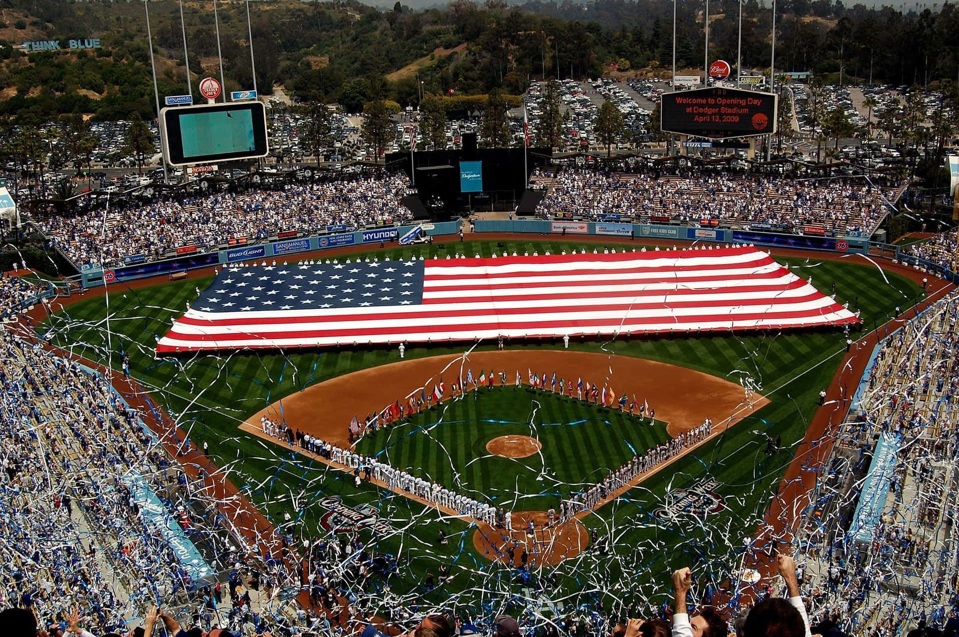 Et baseballstadion med en amerikansk flag som vajer i vinden. Wallpaper