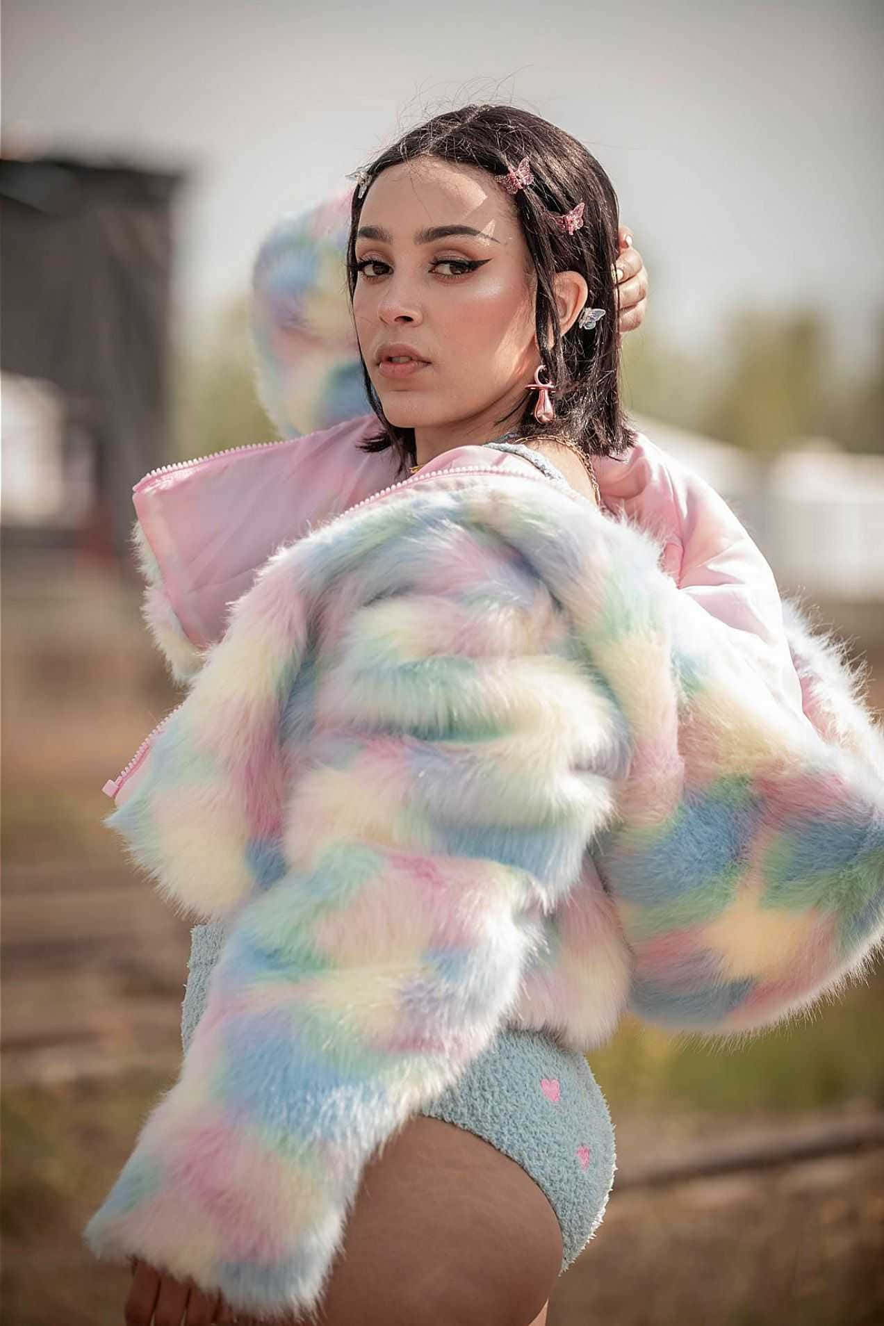 a woman in a colorful fur coat posing