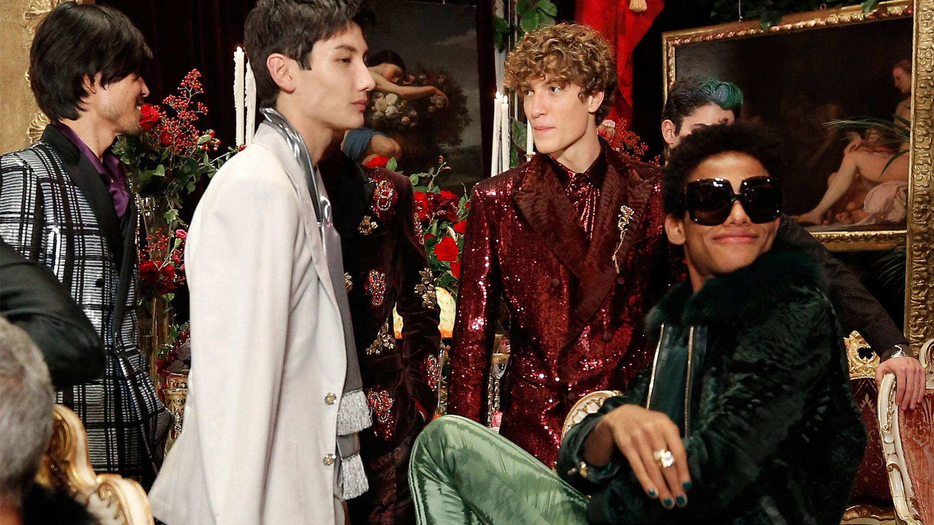 Dolce And Gabbana Models In Extravagant Clothing Sitting Around Wallpaper