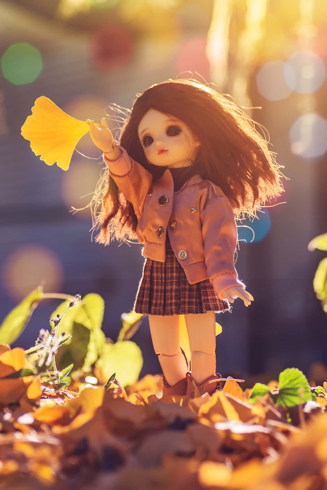 A Doll Is Standing In The Leaves With A Yellow Flower