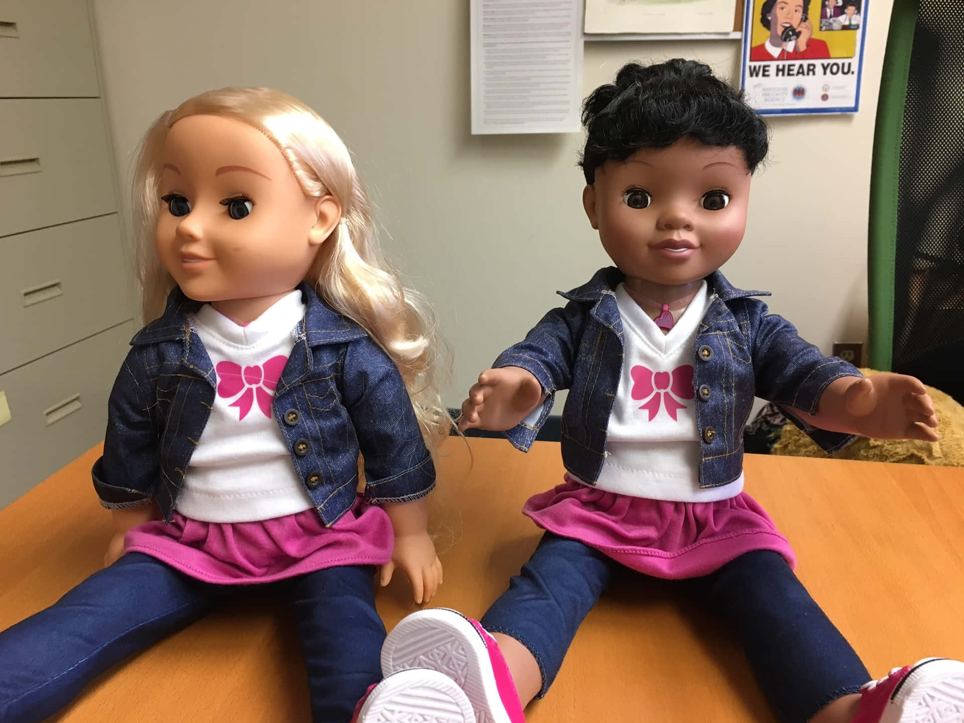 Two American Girl Dolls Sitting On A Desk