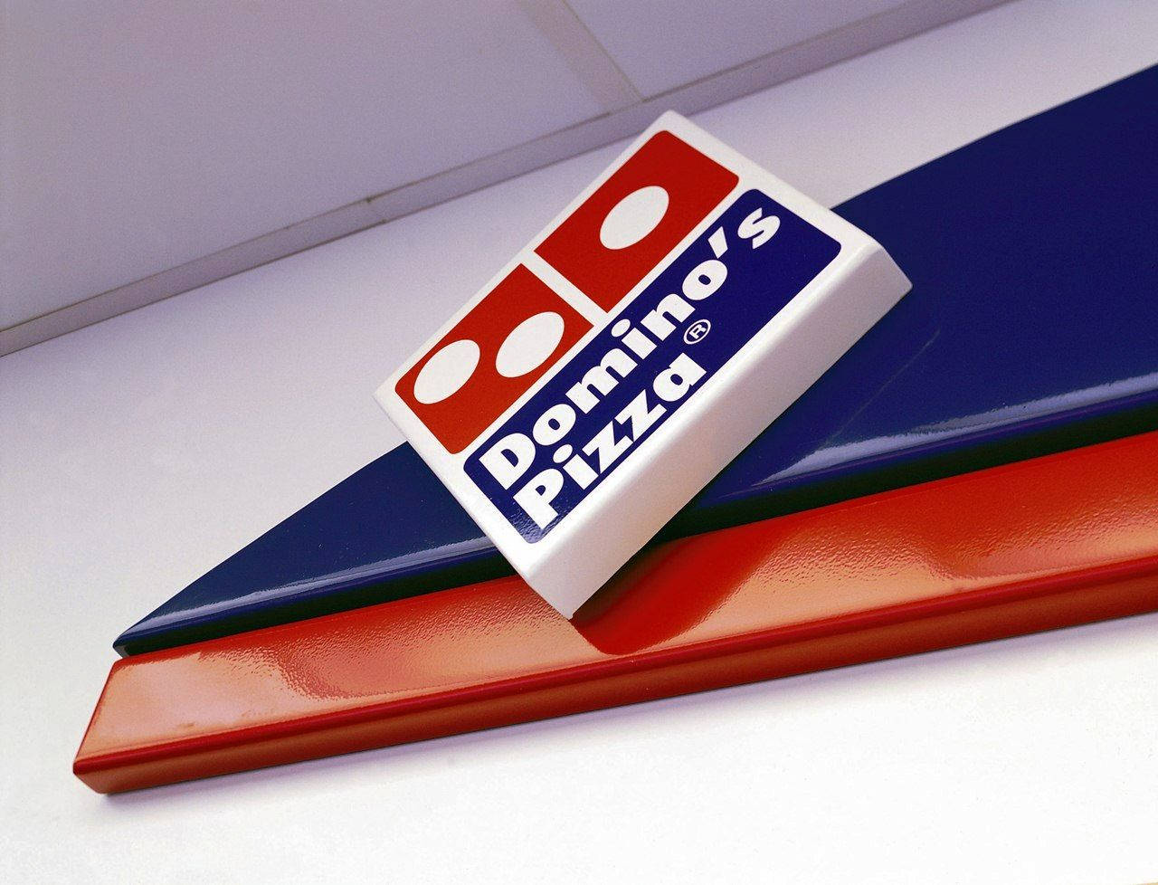 Dominos Pizza Diagonal Logo Tapet: Et design af Dominos Pizza-logo i en diagonalt layout. Wallpaper