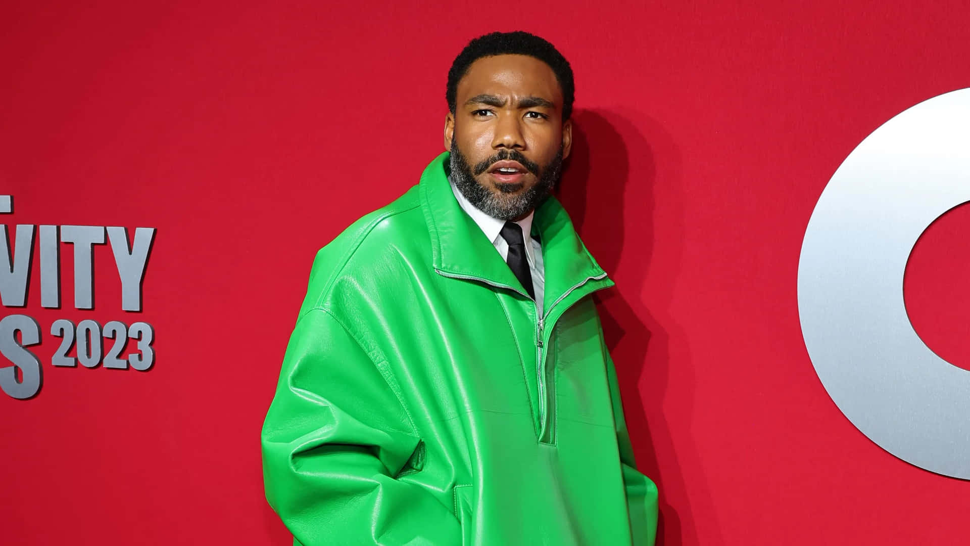 Donald Glover Green Jacket Red Background2023 Wallpaper