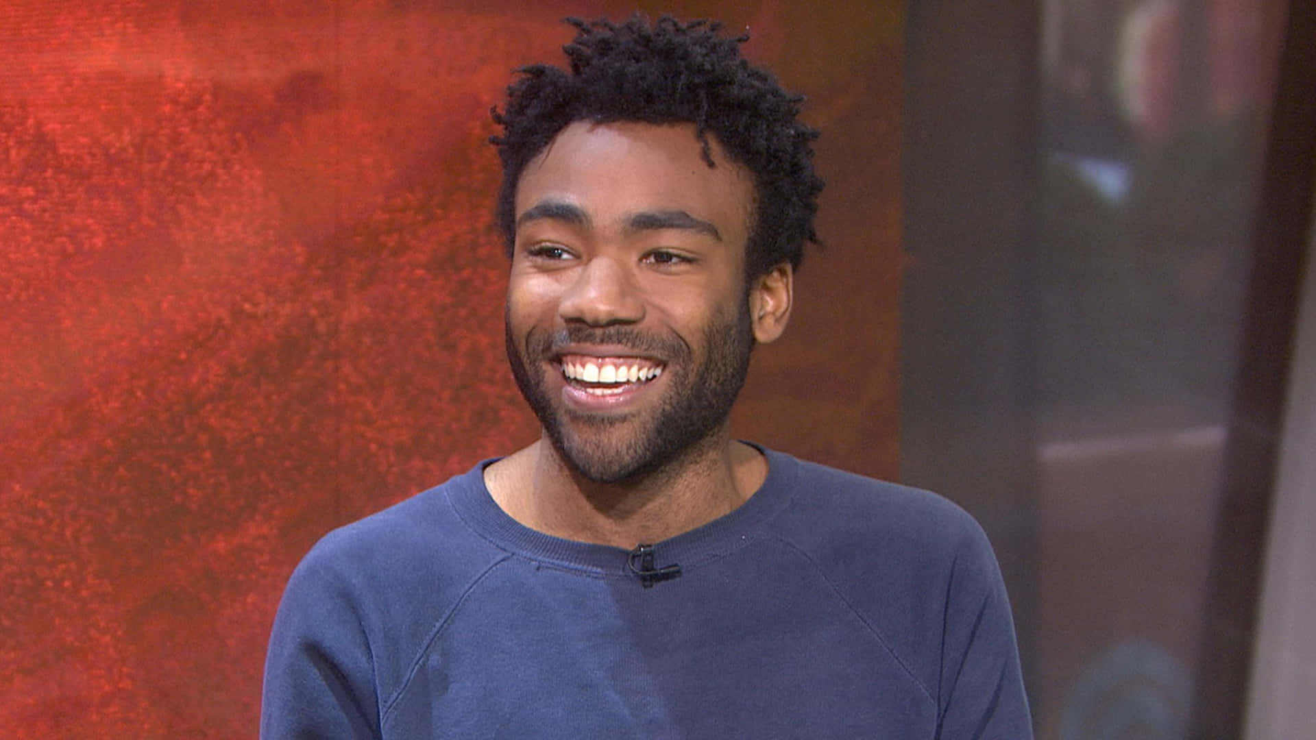 Donald Glover Smiling During Interview Wallpaper