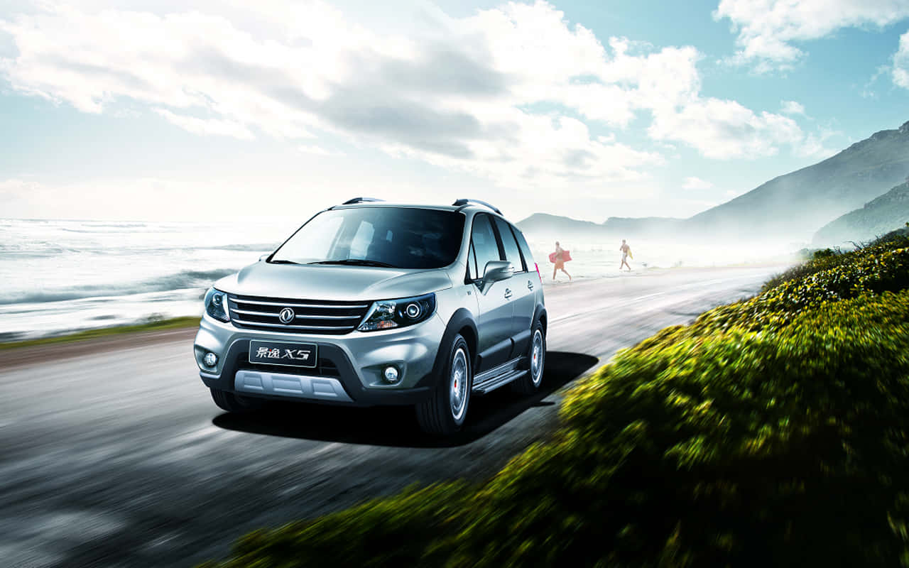 Dongfeng Motor Corporation's commercial vehicle driving on a scenic road Wallpaper