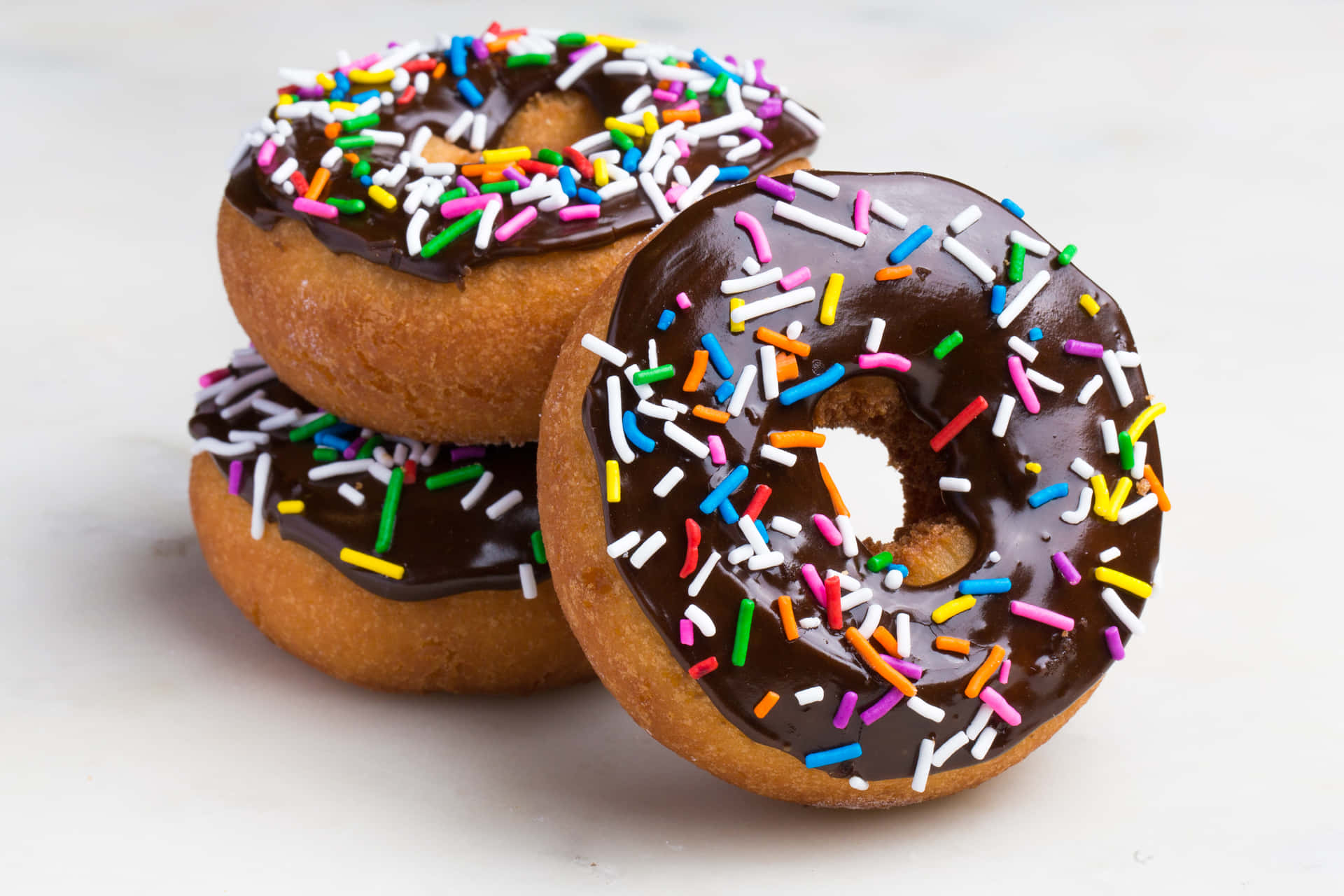 Three Chocolate Glazed Donuts With Sprinkles