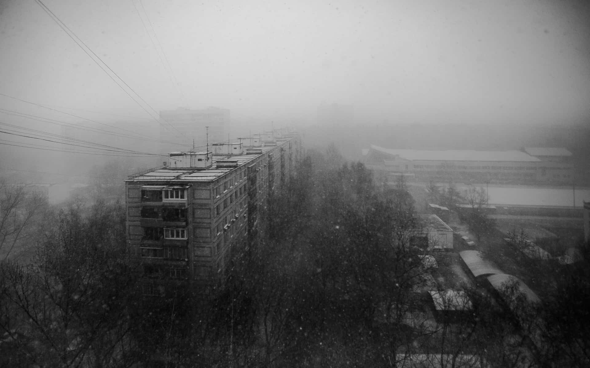 En sort og hvid foto af en by i sneen. Wallpaper