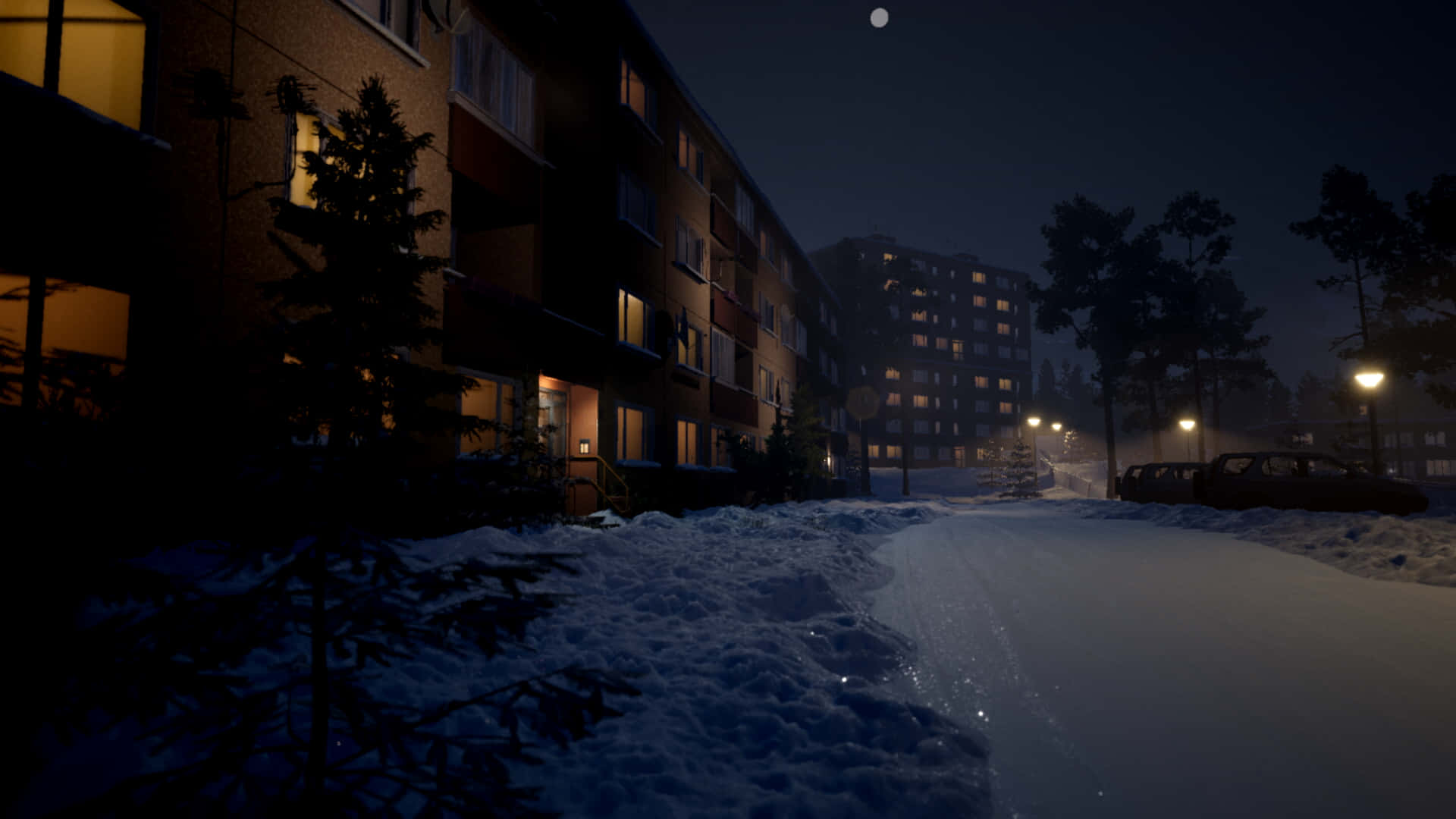 En snedækket gade med bygninger og lys om natten Wallpaper