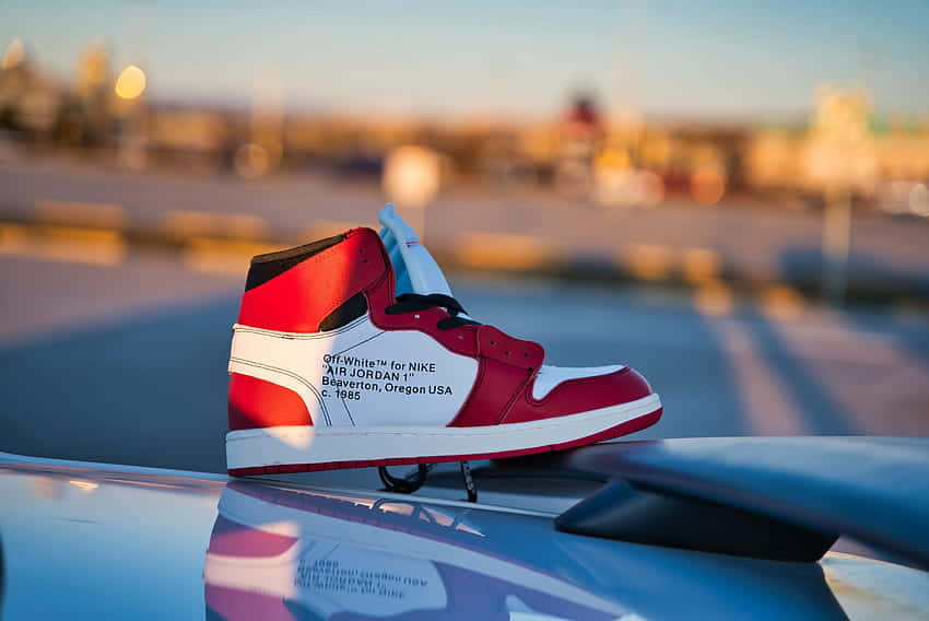 a pair of air jordan 1 high sneakers on top of a car Wallpaper