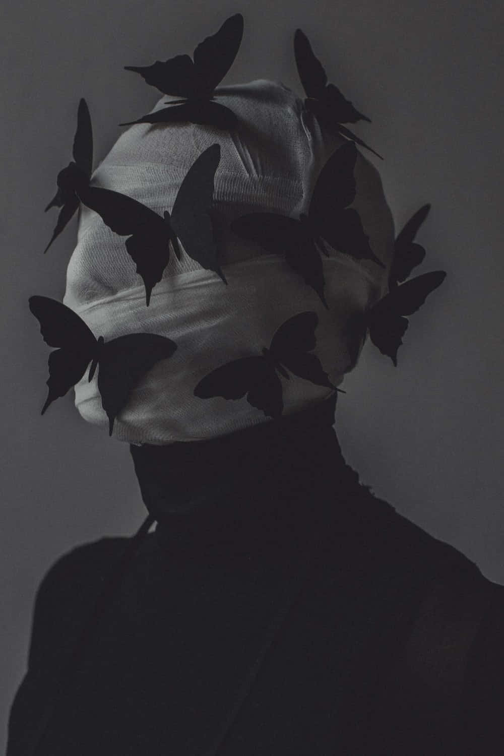 En kvinde med en sort hovedbeklædning og sommerfugle på hendes hoved.