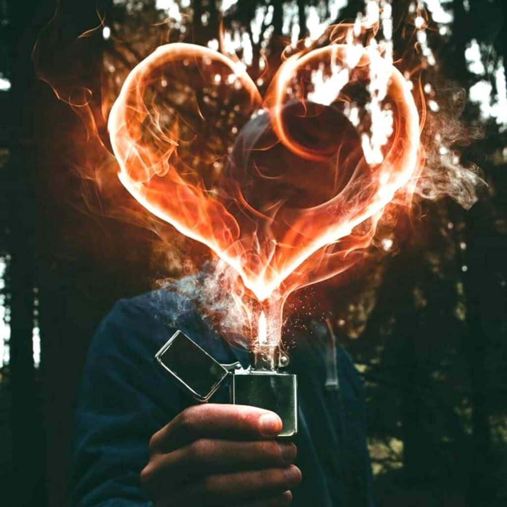 A Man Holding A Lighter With A Heart Shape In It